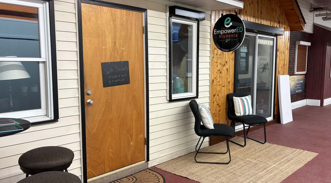 The front door with a handwritten chalkboard welcome sign and chairs for waiting parents